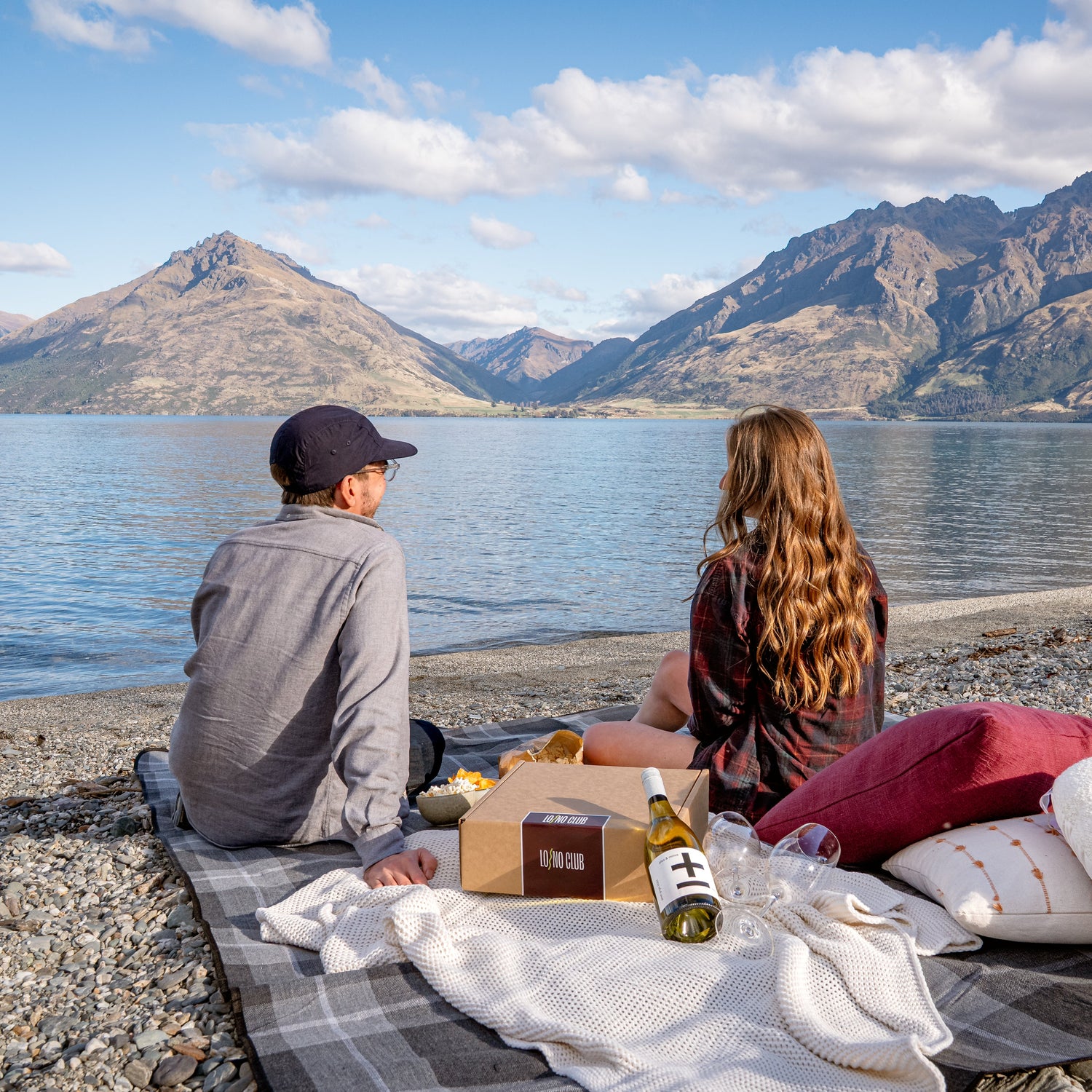 The founders of LONO Club sitting at a lakeside picnic on the shores of Lake Wakatipu Queenstown.